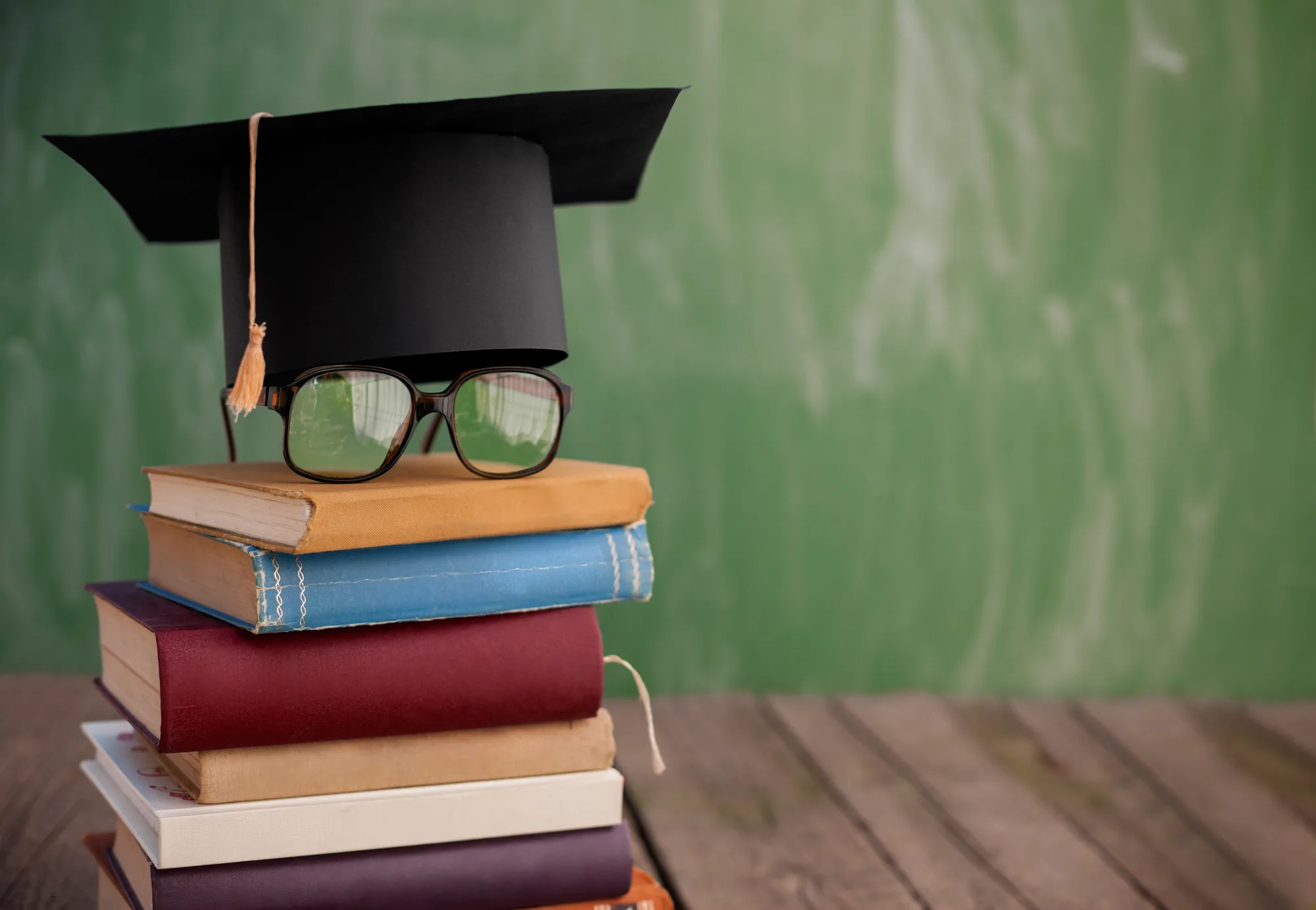 Книги з окулярами та академічною шапкою