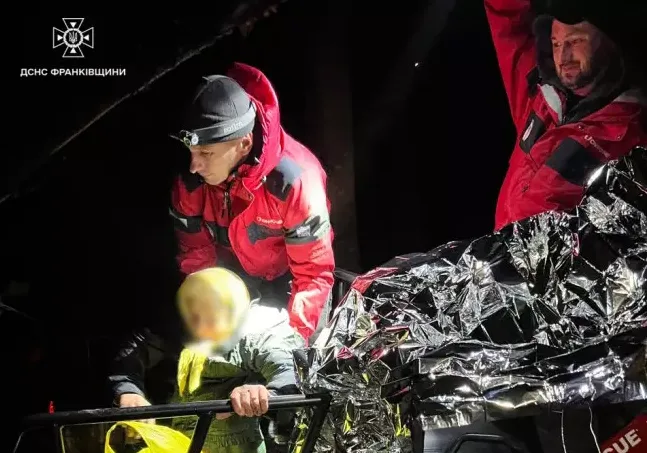 Рятувальники допомагають людині в авто вночі