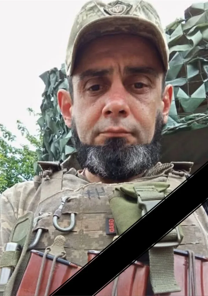 Український військовий у камуфляжі з чорною стрічкою