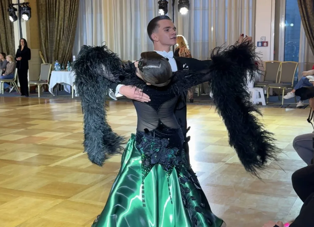 Пара танцює бальний танець у залі