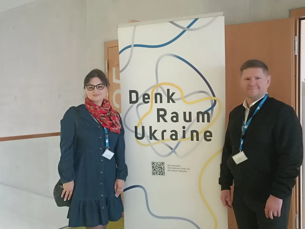 Двоє людей біля банера Denk Raum Ukraine