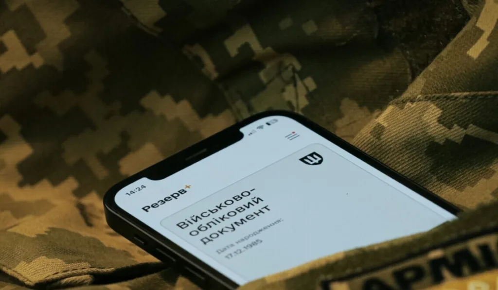 Смартфон із військовим документом на камуфляжі