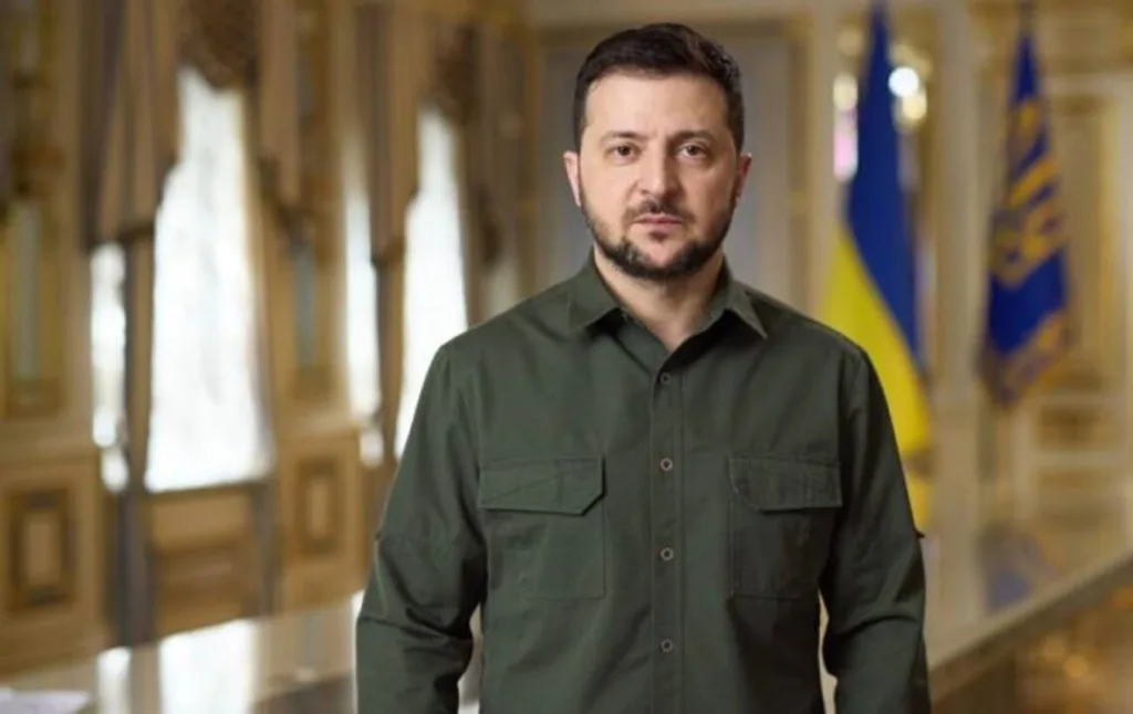 Чоловік у зеленій сорочці стоїть у залі