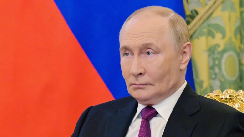 Чоловік у костюмі на тлі прапора Росії