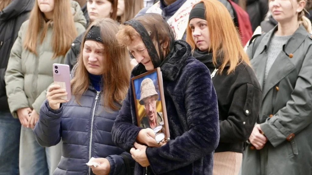 Жінки плачуть на церемонії прощання з військовим