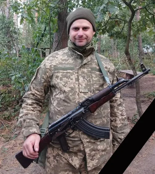 Військовий у камуфляжі з автоматом у лісі