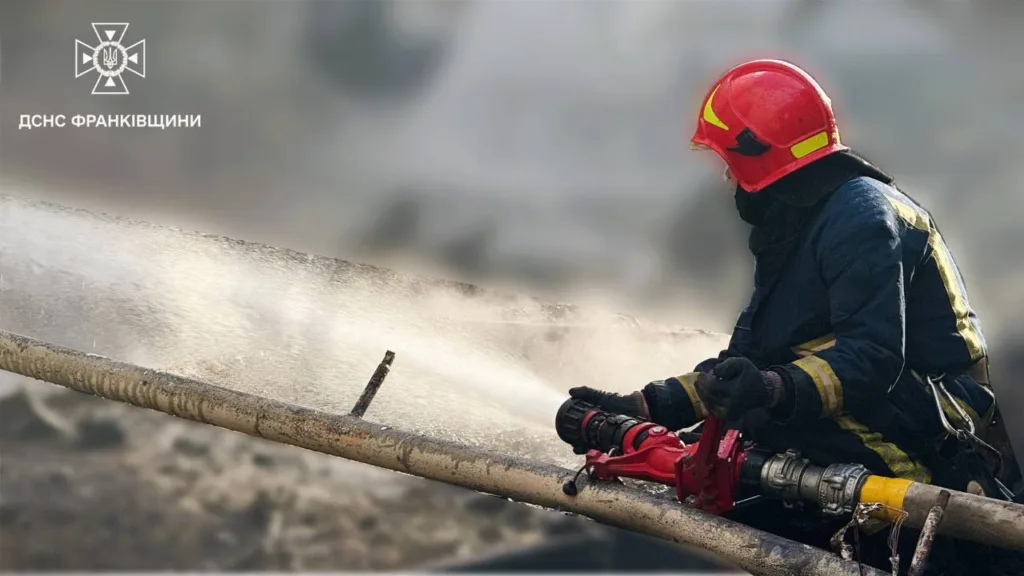 Пожежник гасить вогонь зі шланга