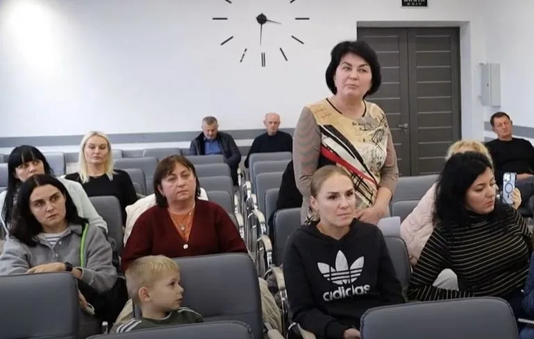 Жінка виступає на зібранні у конференц-залі