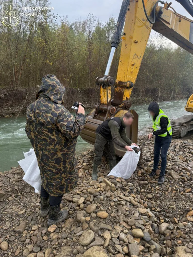 Люди працюють біля екскаватора на березі річки