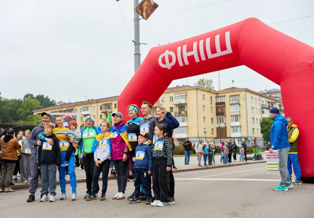 Забіг, учасники з прапорами біля фінішу