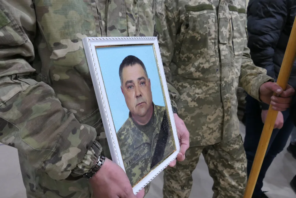 Військовий тримає портрет у формі.