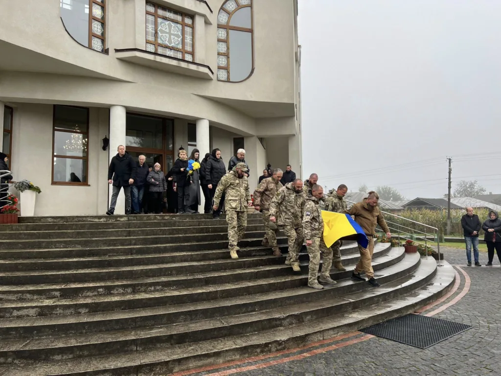 Військові несуть труну з українським прапором