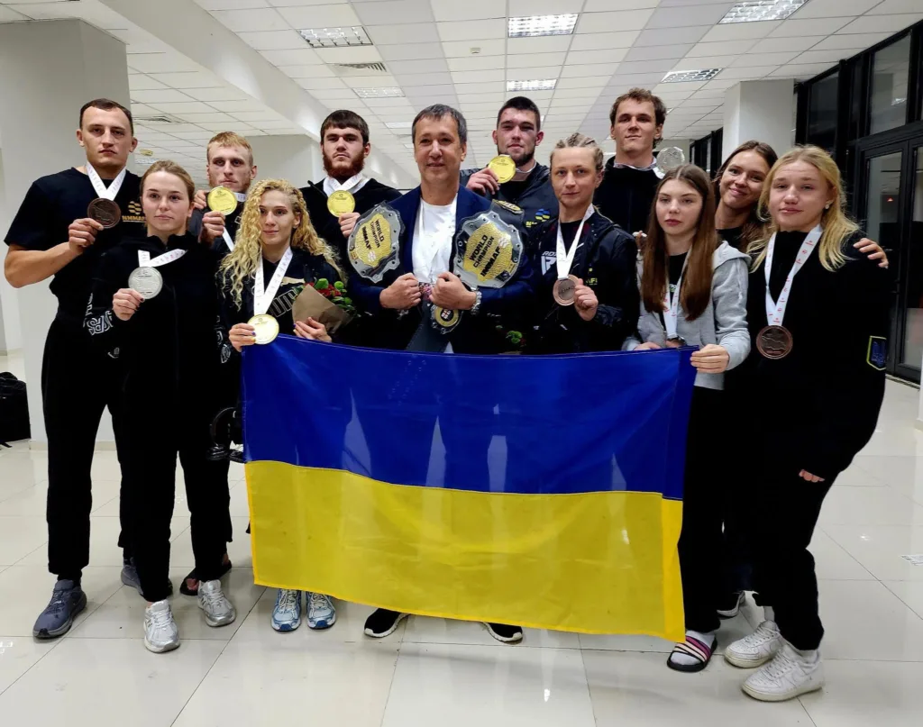 Українські спортсмени з медалями та прапором.
