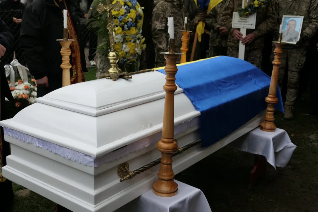 Труна з українським прапором на похороні військового.