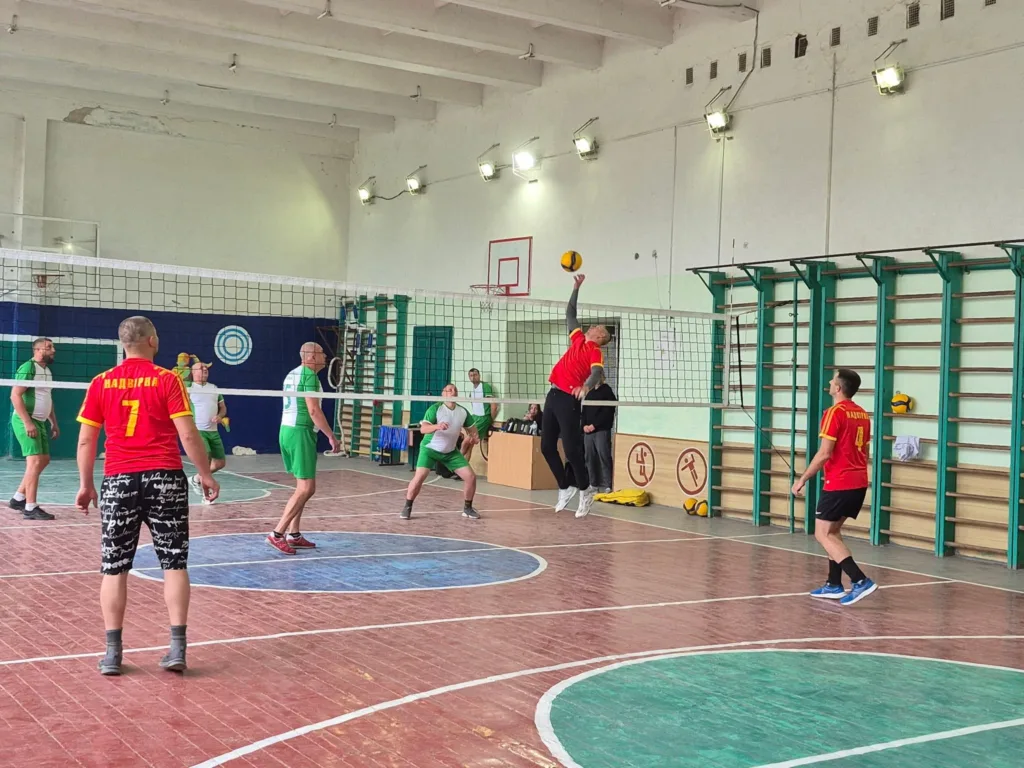 Чоловіки грають у волейбол у спортивному залі
