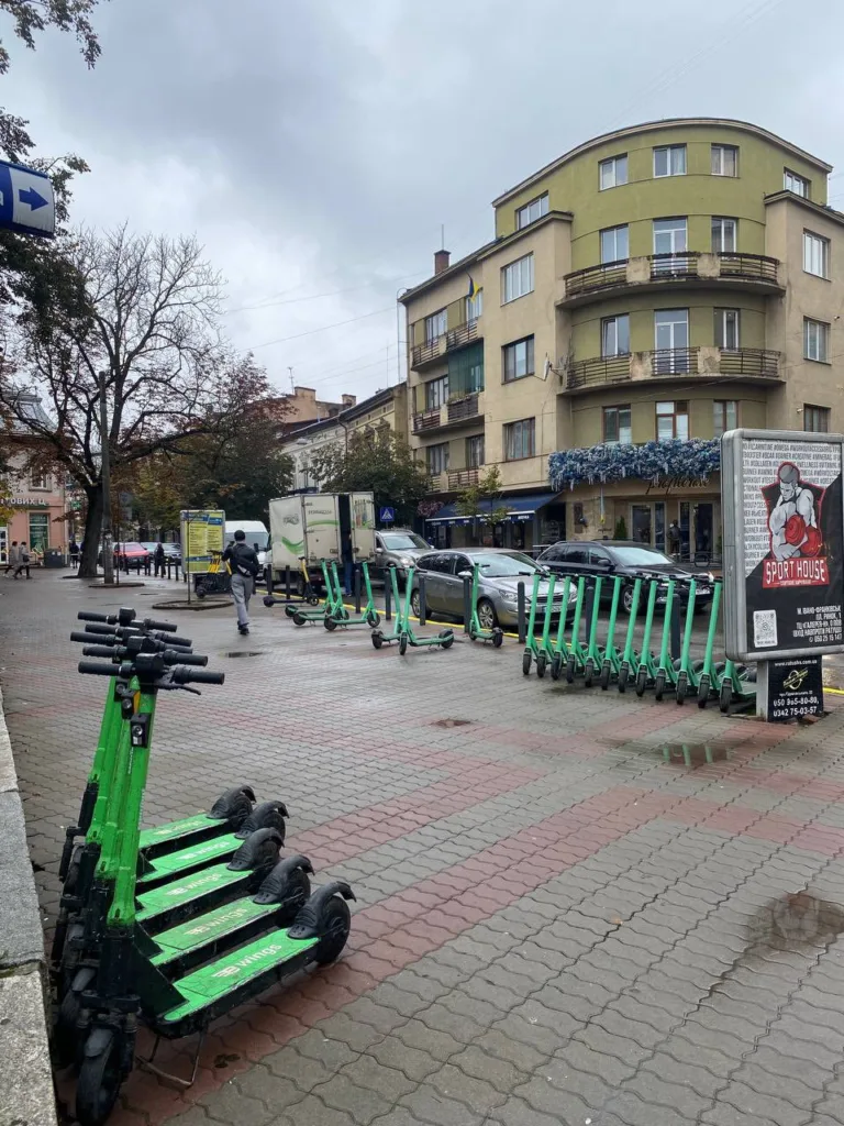 Ряд зелених електросамокатів на міській вулиці