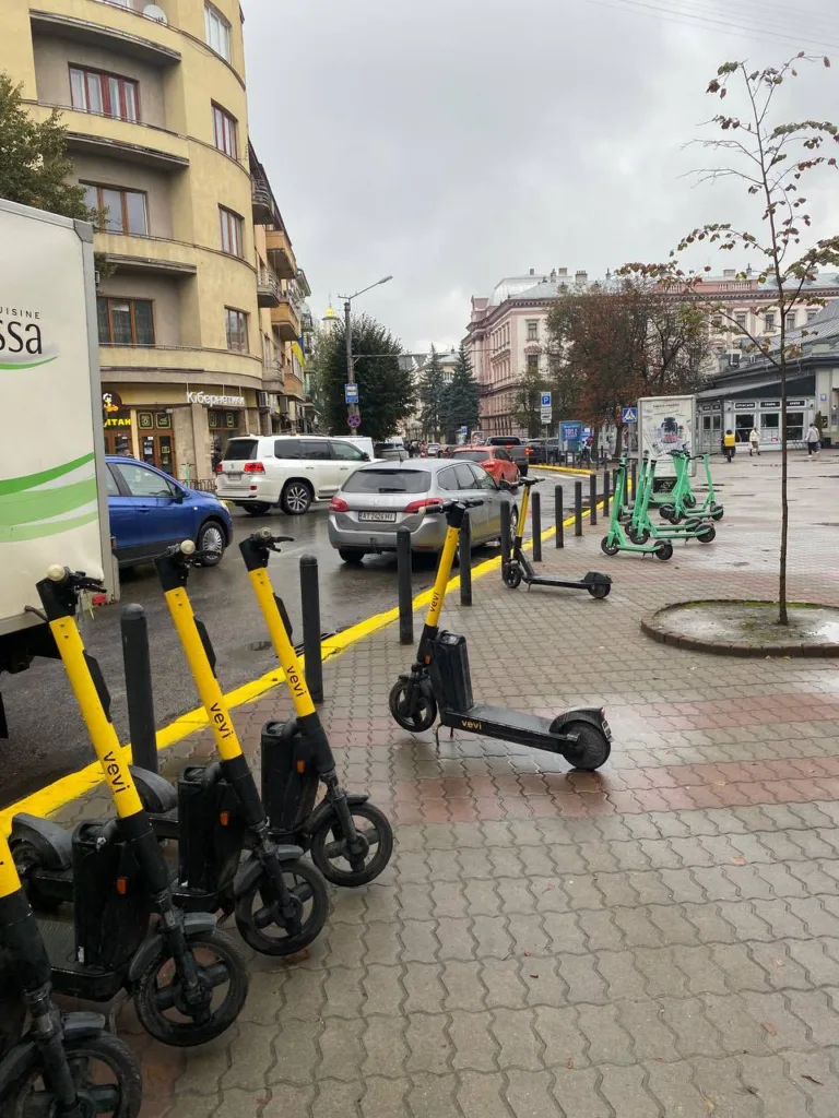 Вулиця міста з електросамокатами біля тротуару