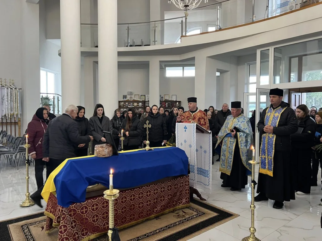 Церковна служба біля труни в приміщенні храму.