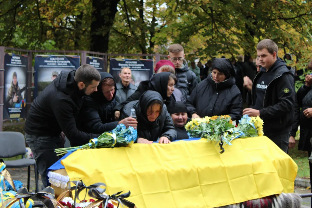 Прощання з загиблим воїном під українським прапором