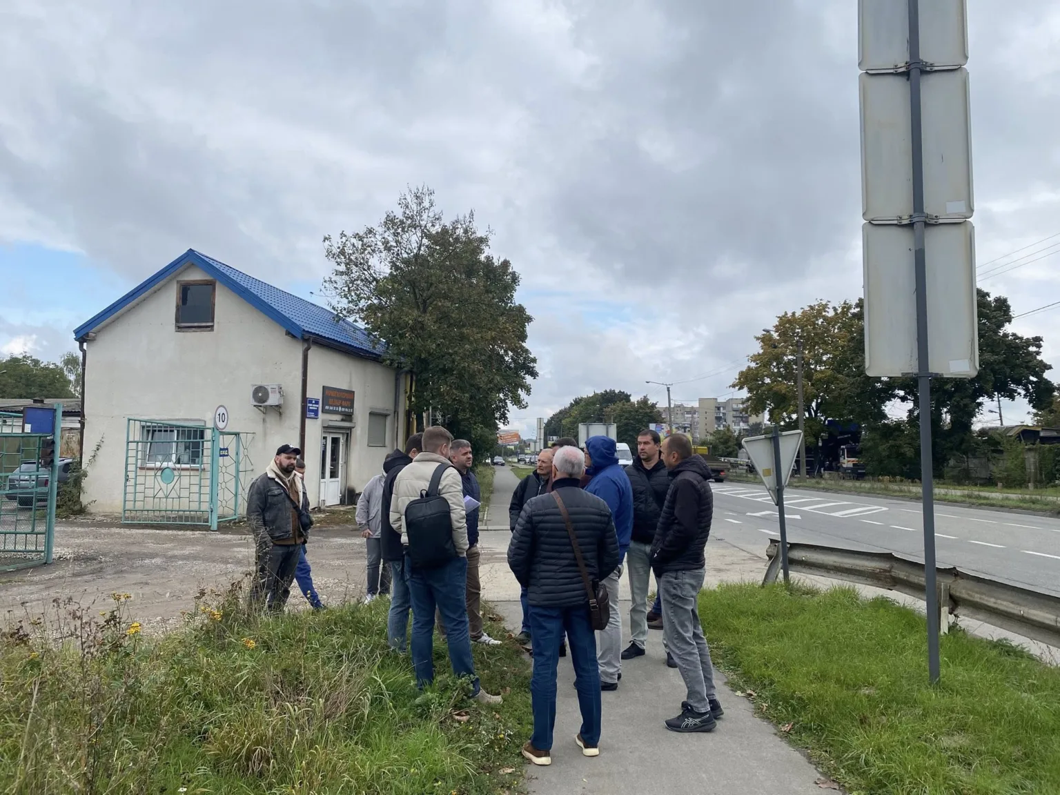 Люди стоять біля будівлі на вулиці