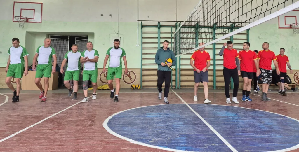 Чоловіки у спортивній залі готуються до волейболу