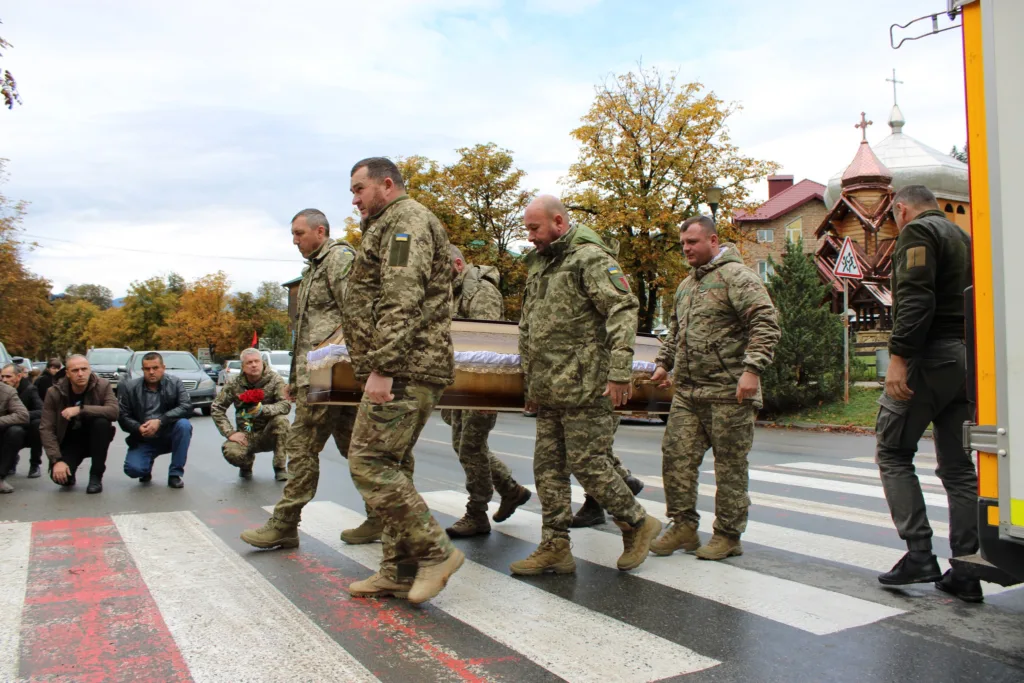 Військові несуть труну на похороні героя