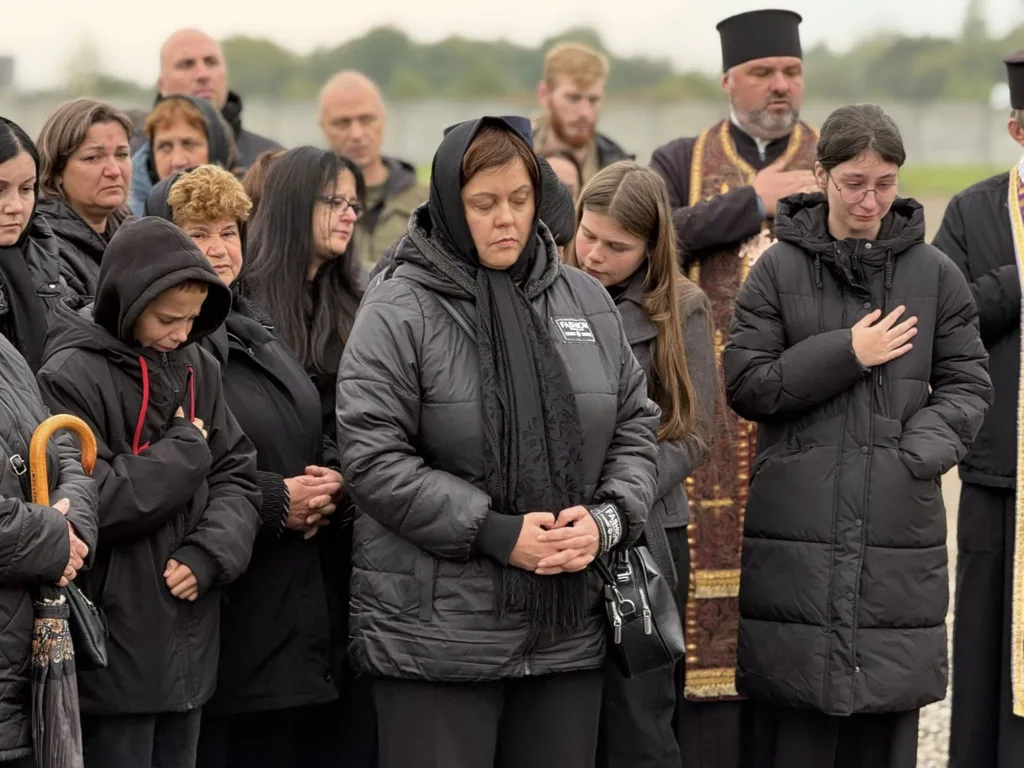 Люди моляться під час траурної церемонії