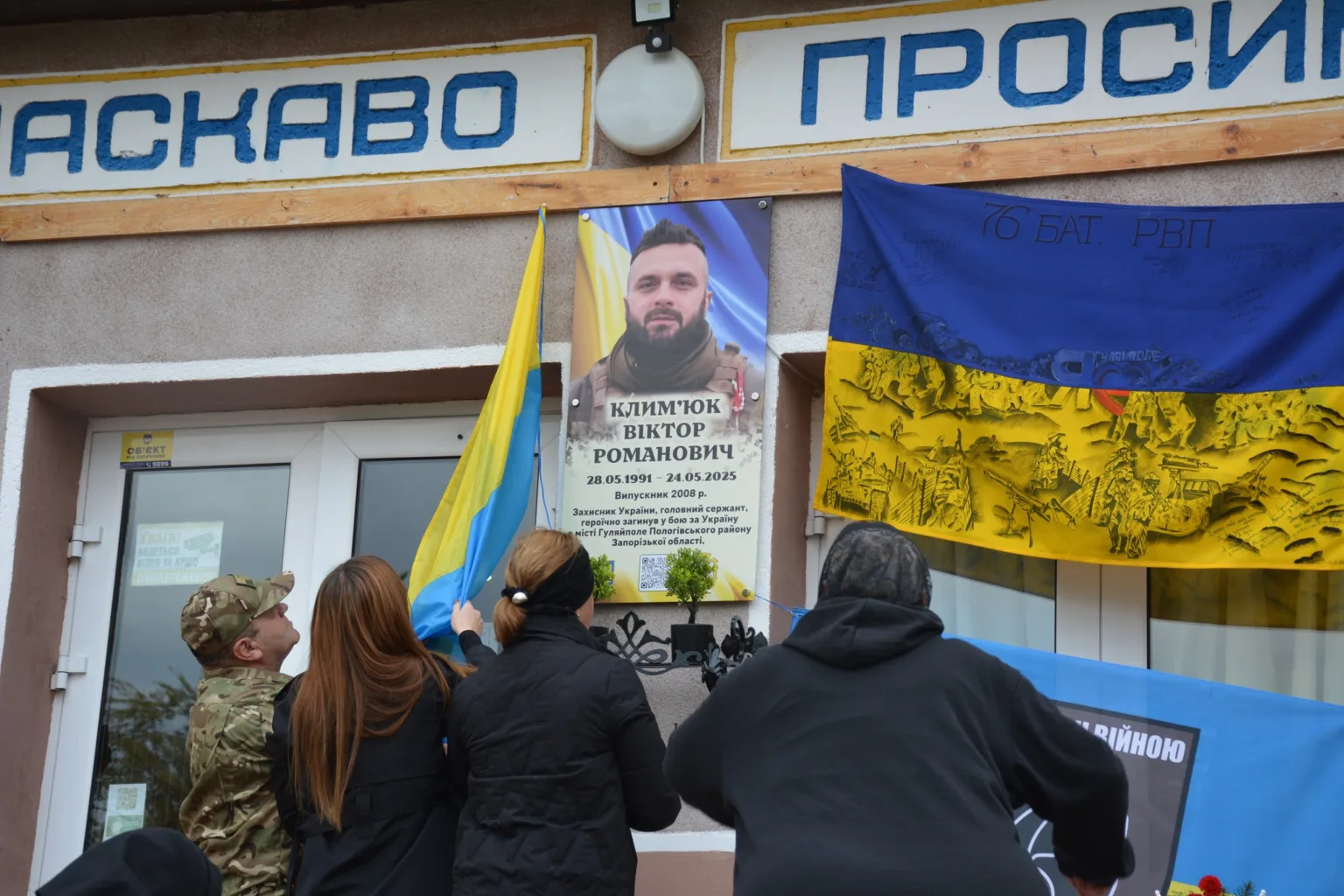 Вшанування пам’яті українського захисника з прапорами