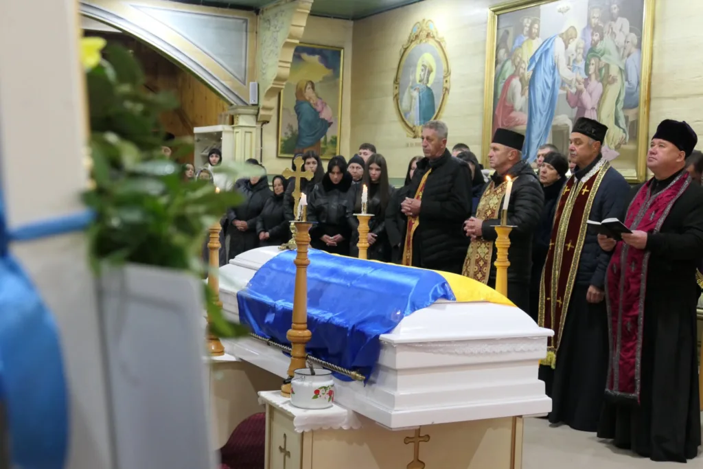 Похоронна служба з українським прапором на труні