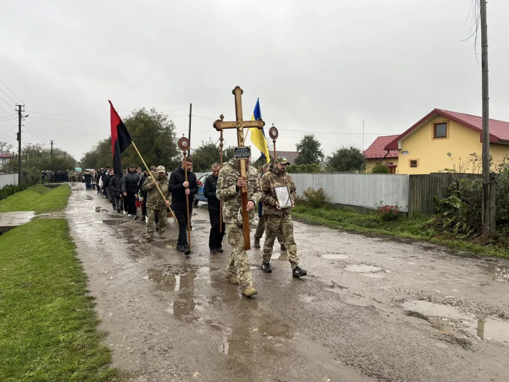 Урочиста хода на вулиці з прапорами і хрестом.