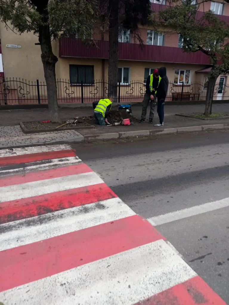 Робітники ремонтують тротуар біля пішохідного переходу