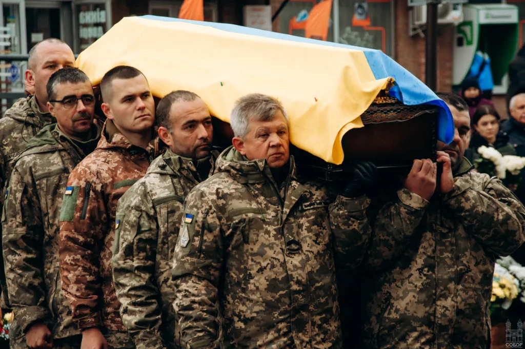 Військові несуть труну з українським прапором