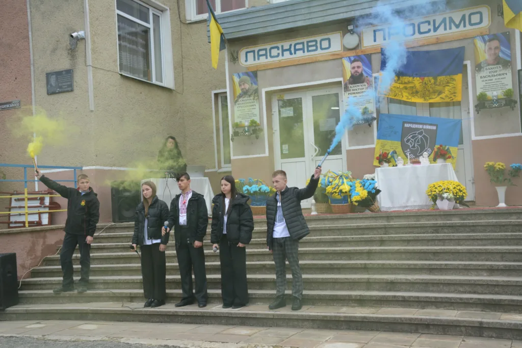 Учні на шкільній церемонії з жовтим і синім димом