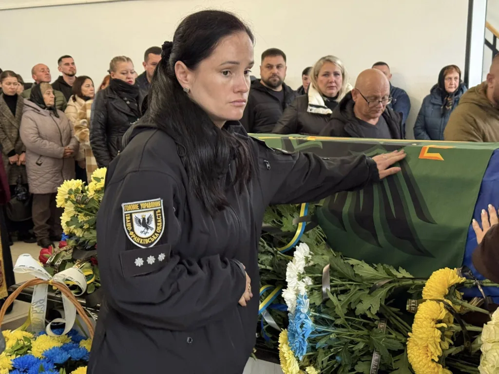 Жінка прощається з військовим героєм на похороні