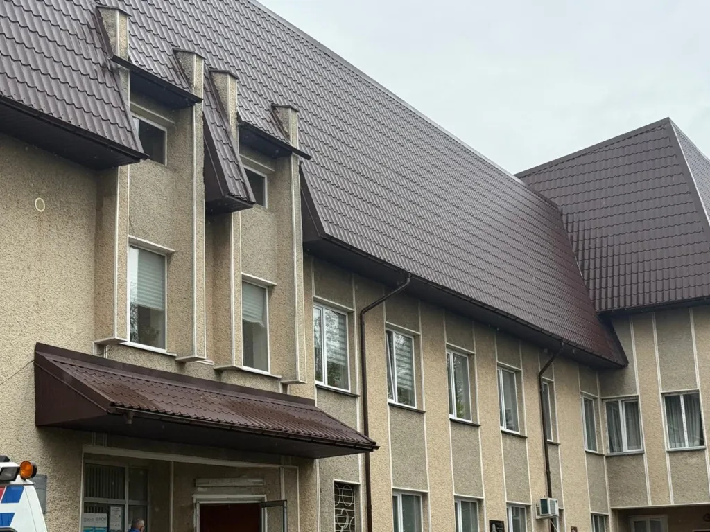 Будівля з коричневим дахом та вікнами