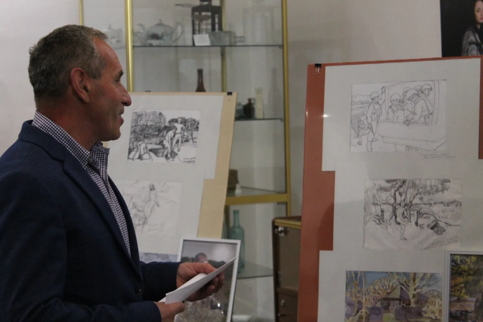 Чоловік презентує виставку малюнків у галереї