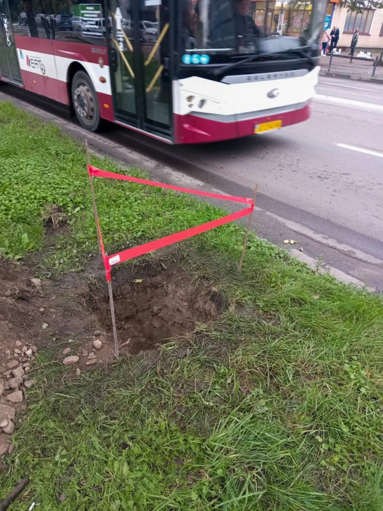Яма біля дороги, огороджена червоною стрічкою