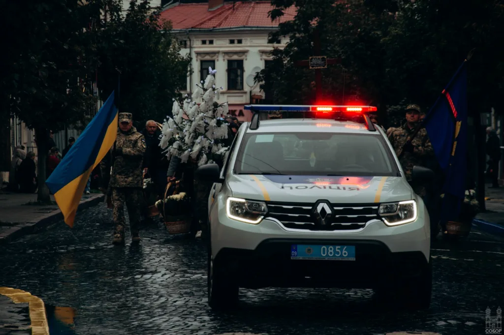 Українська поліція супроводжує військову процесію з прапорами
