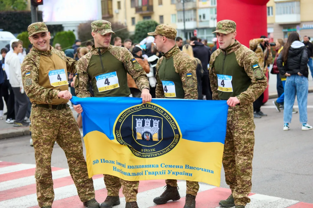 Військові тримають прапор на параді в Україні.