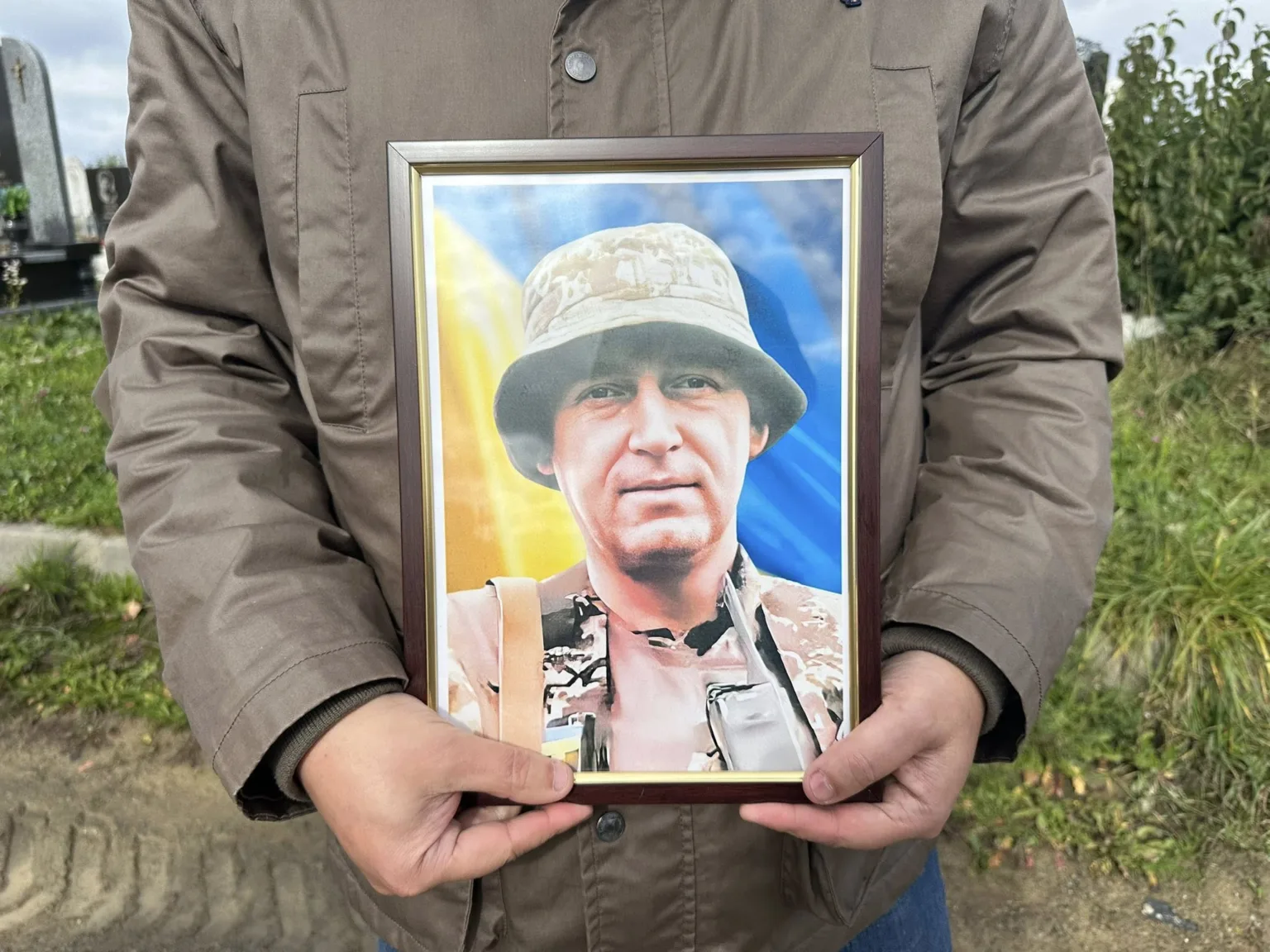 Людина тримає фото українського військового