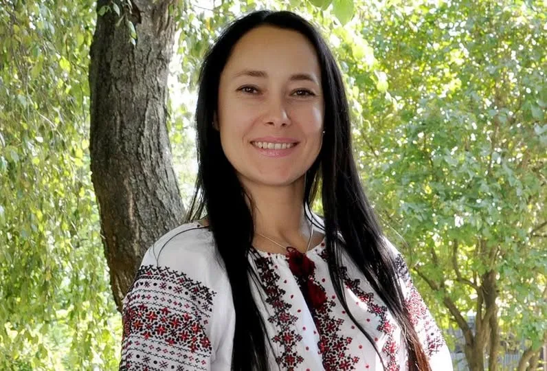 Жінка у вишиванці на природі, усміхнена