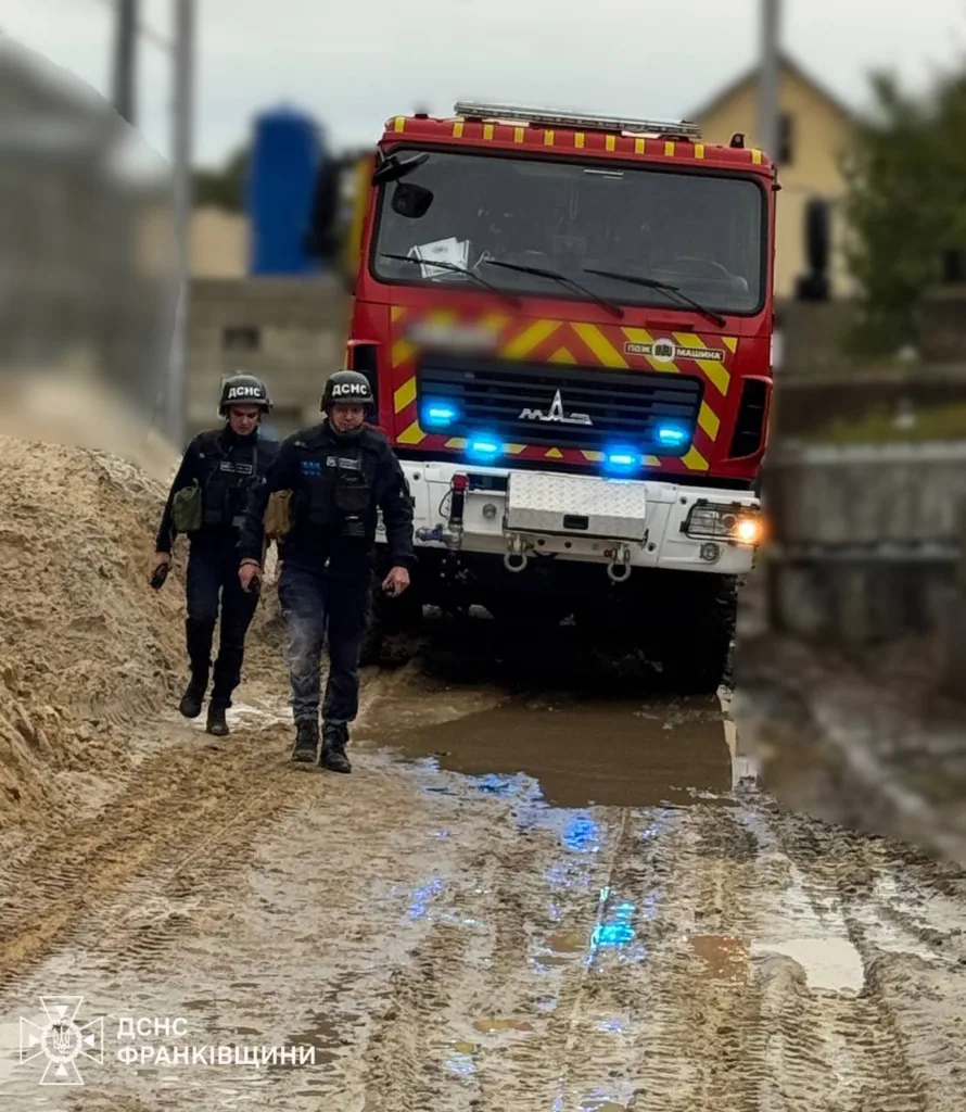 Рятувальники та пожежна машина на ґрунтовій дорозі