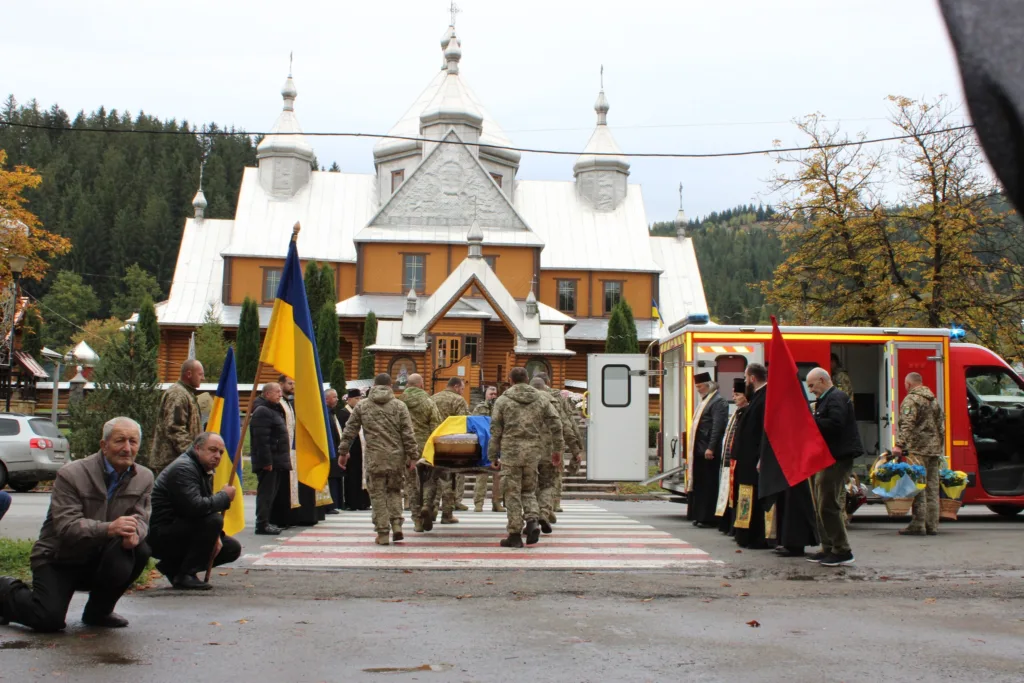 Військовий похорон біля церкви в українському селі