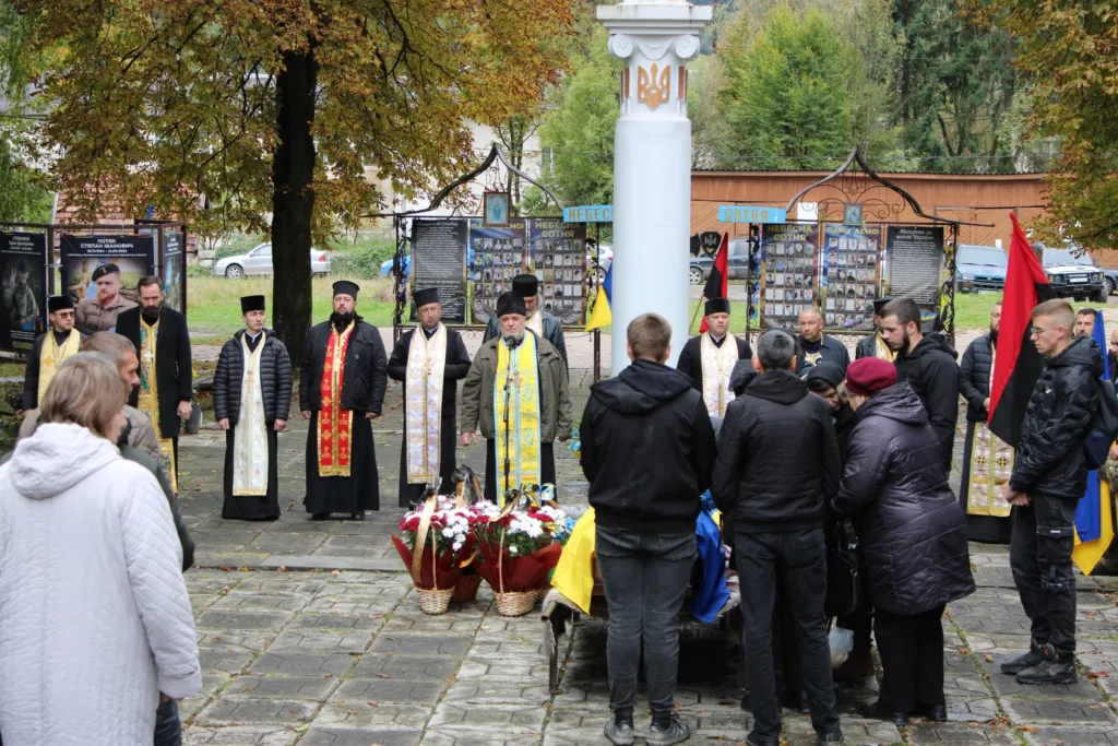 Люди вшановують полеглих героїв на меморіалі.