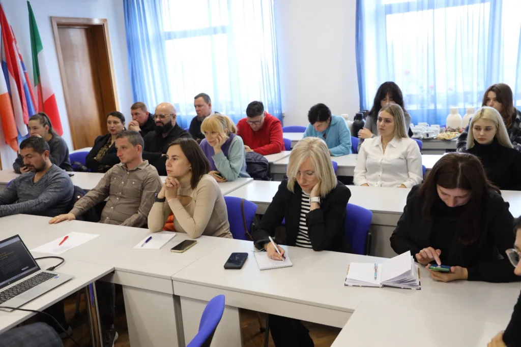 Люди слухають лекцію в аудиторії.