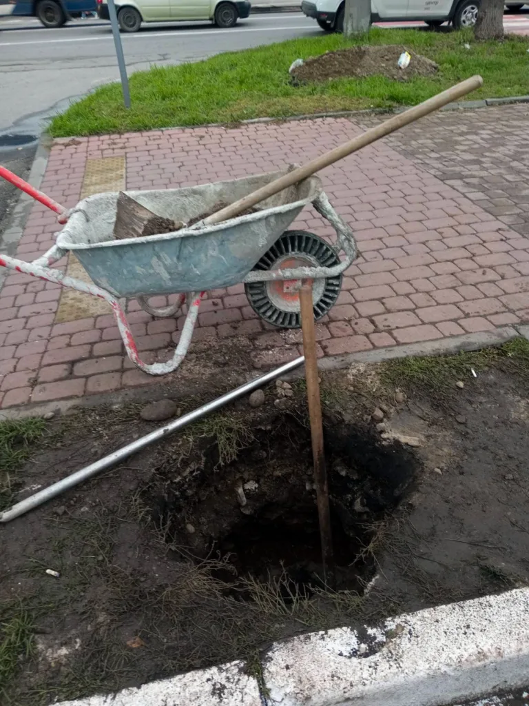 Будівельний візок біля ями на тротуарі
