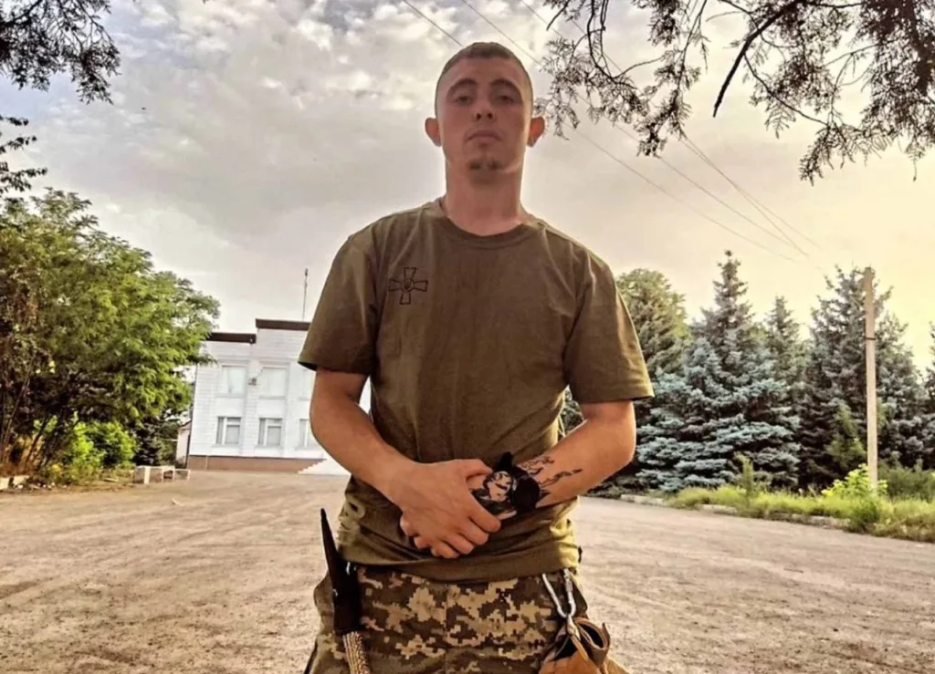 Український військовий на вулиці біля дерев