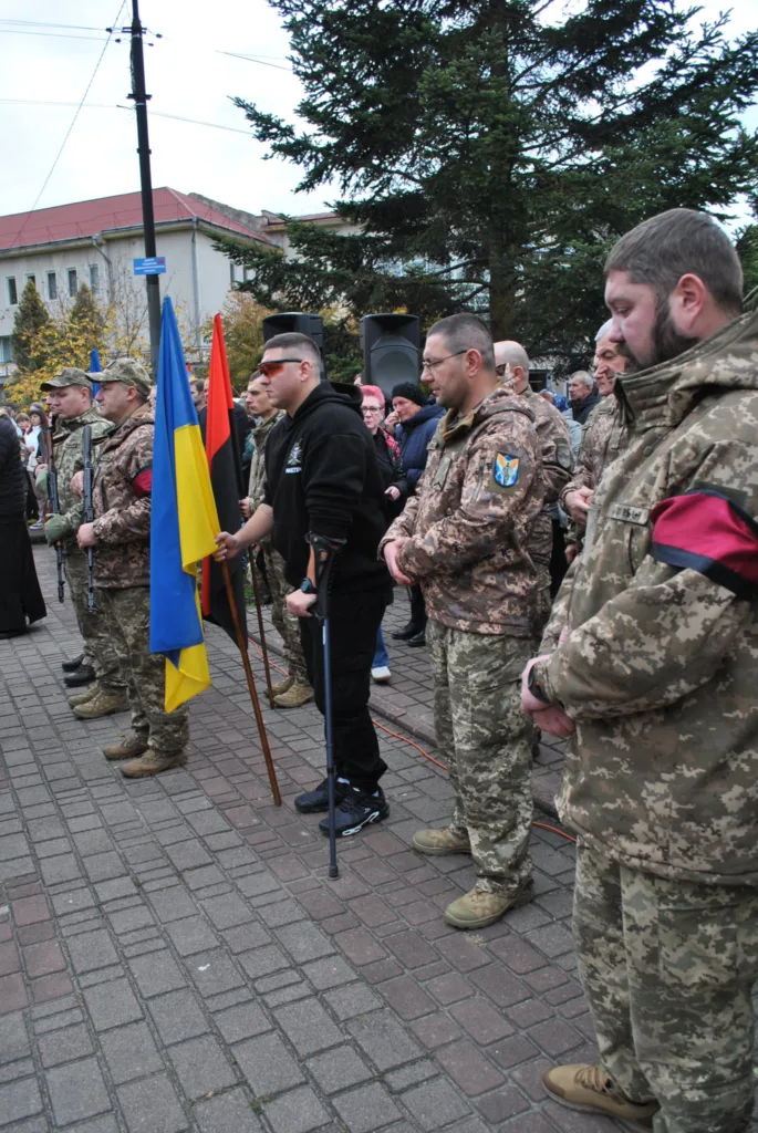 Українські військові тримають прапори на вуличній церемонії