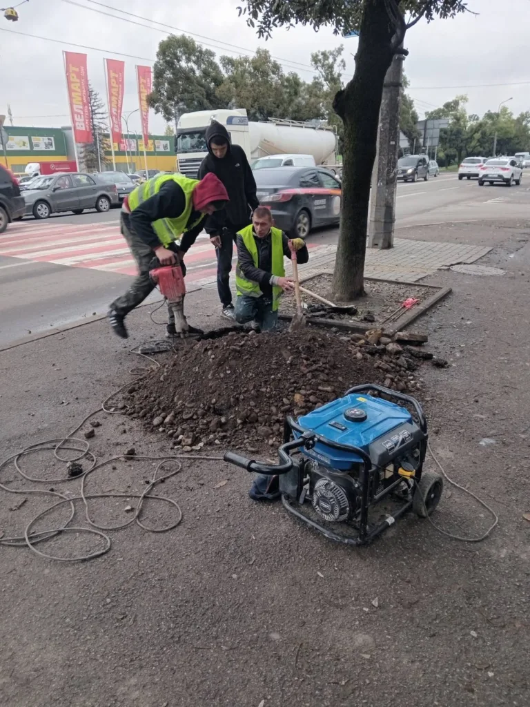 Робітники ремонтують тротуар біля дороги