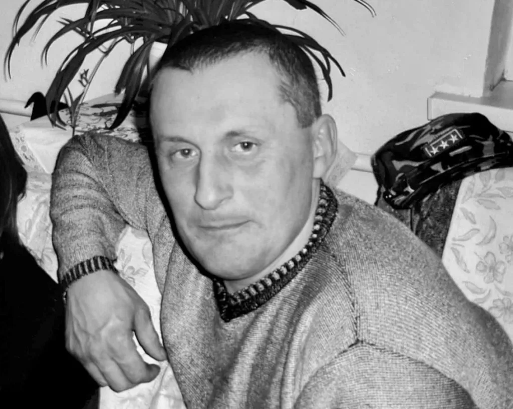 Чоловік у светрі сидить на дивані